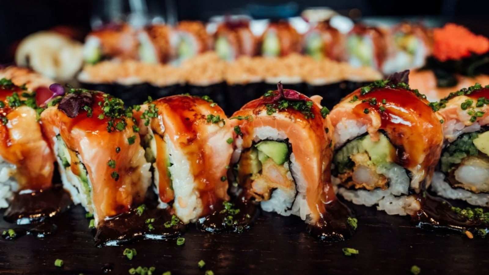 A row of sushi on dark wood at the 794 JIDAI bar