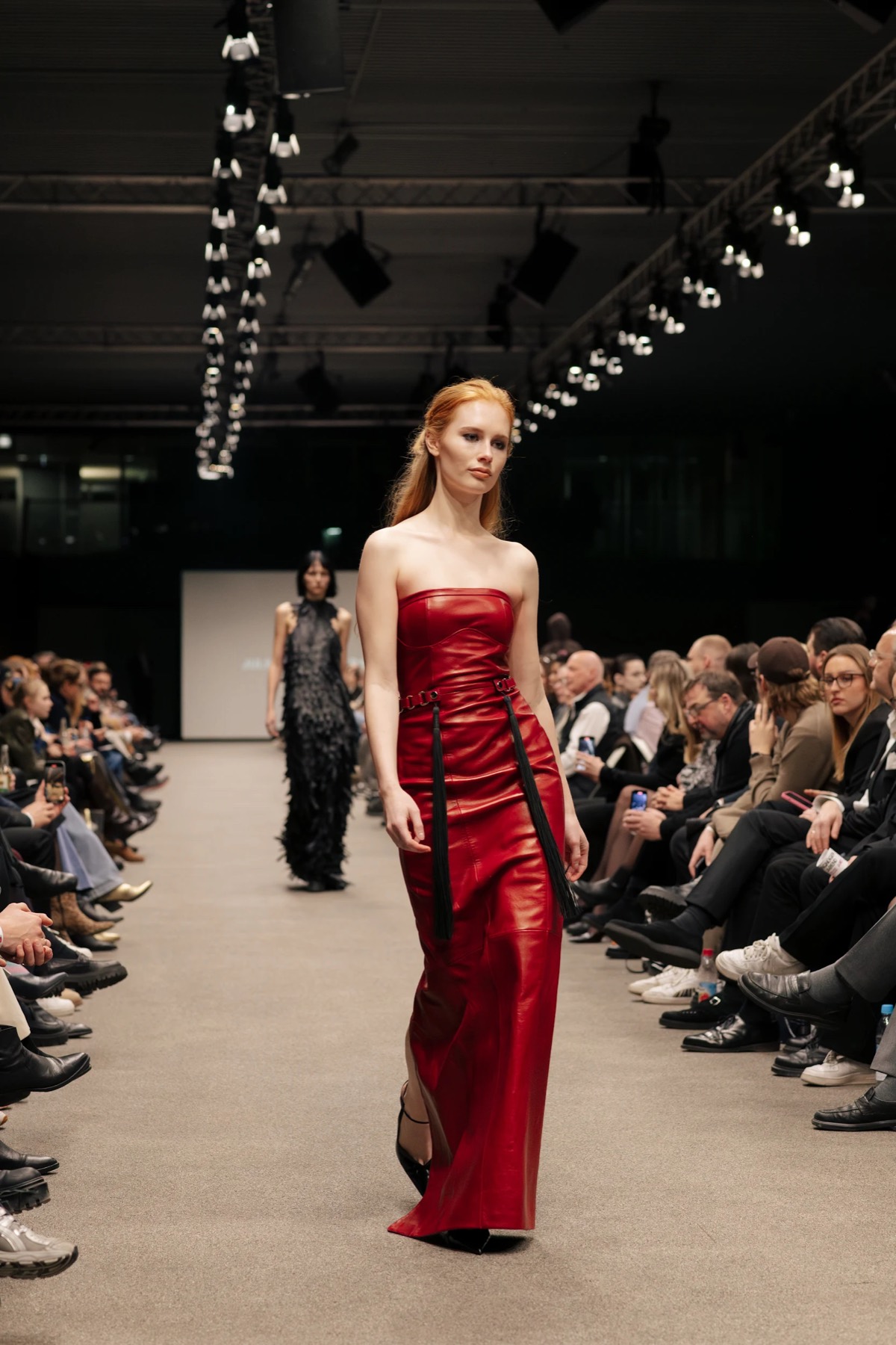 A model in a red leather dress on the runway