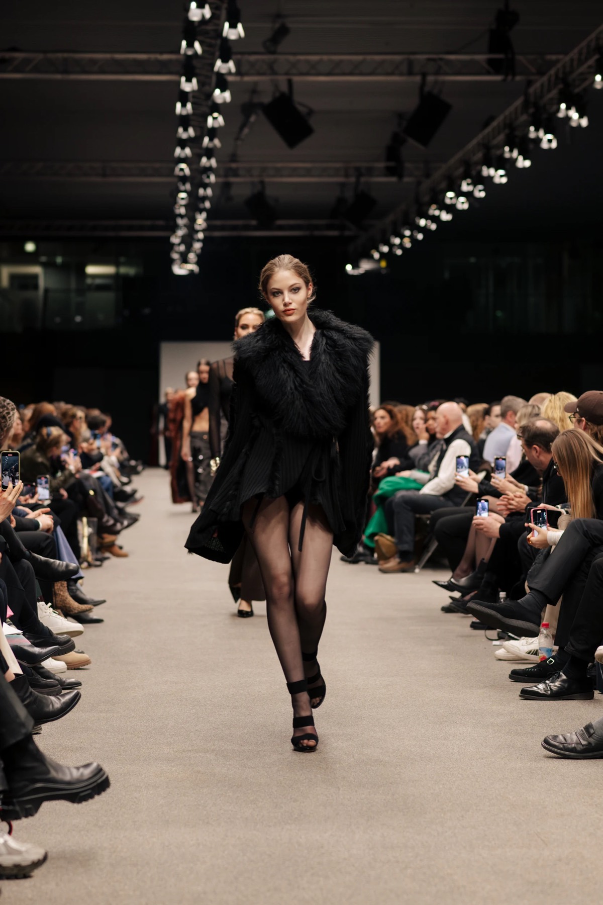 Two models in black on the runway at an AMD show